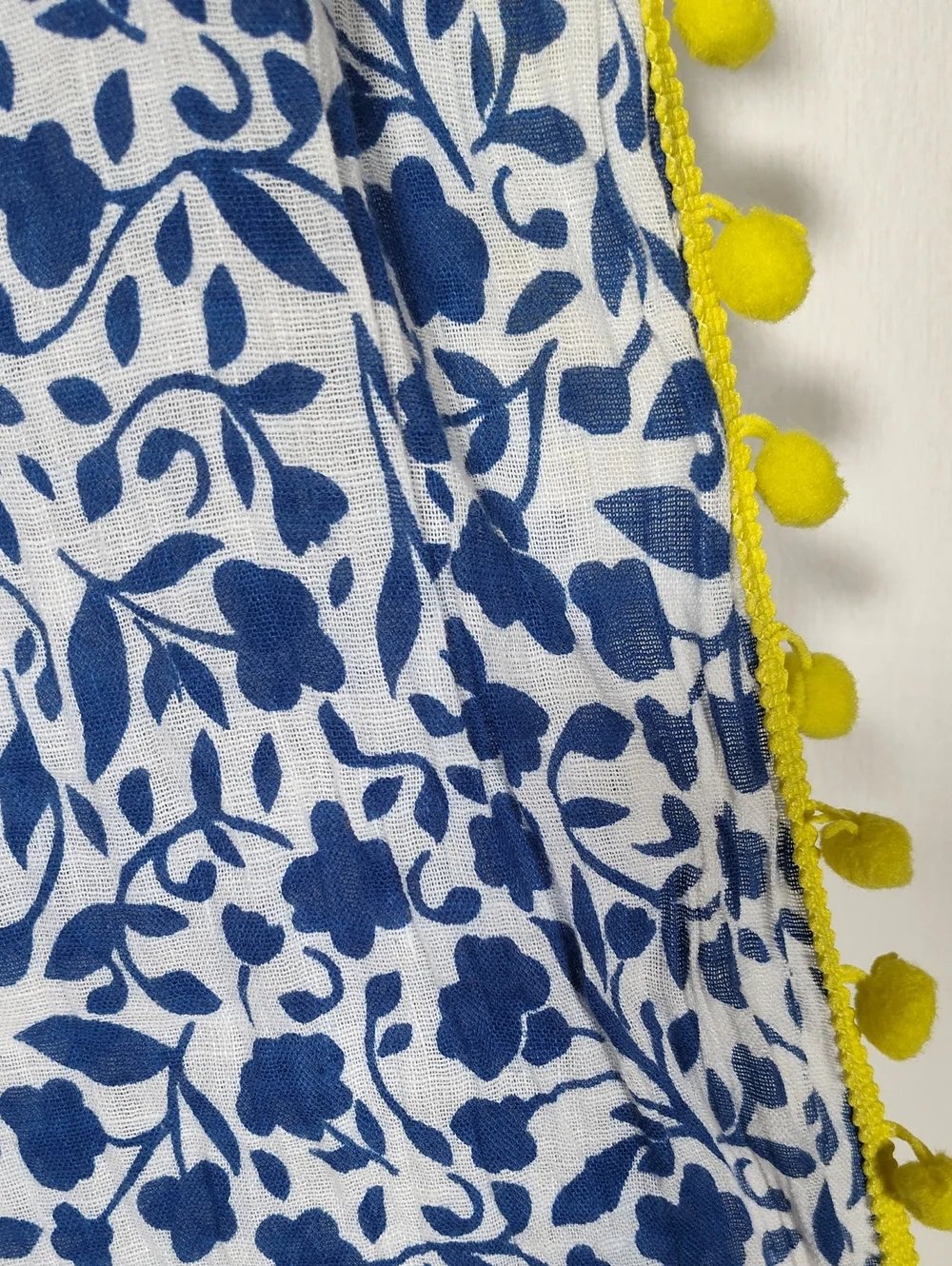 White and‎ blue floral pattern scarf with bright yellow pom pom trim